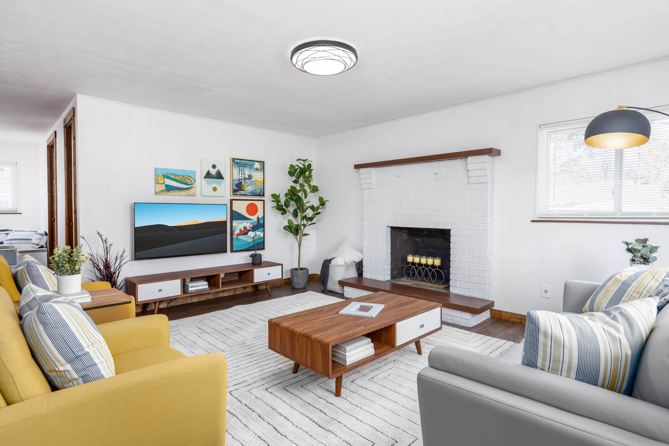 Modern living room with yellow and gray furniture with artwork on the wall. Located in Buckeye Lake, Ohio.